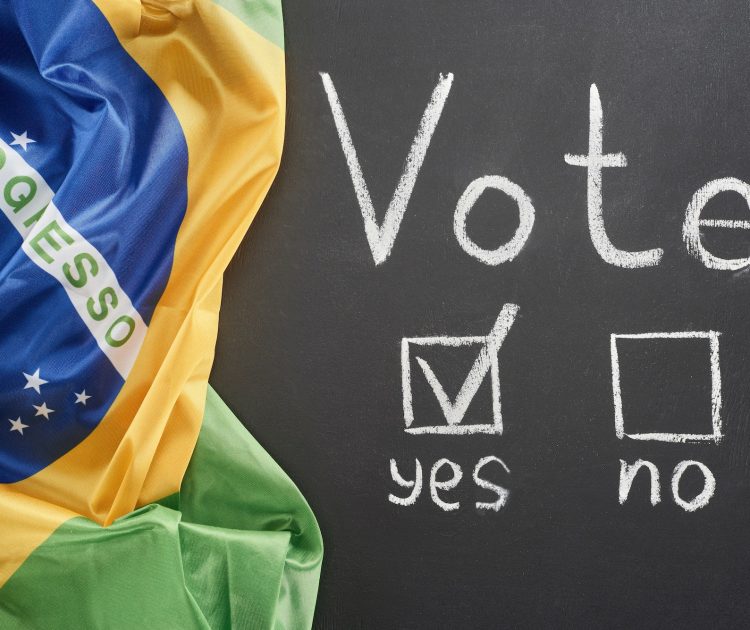 top view of white vote lettering and check mark near yes word on black chalkboard near flag of